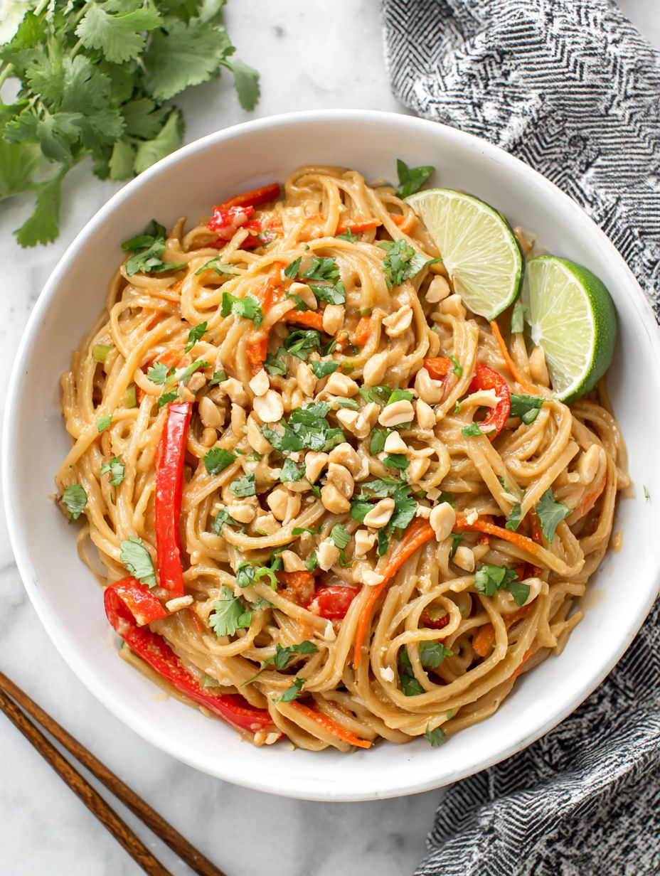 A bowl of noodles with vegetables and nuts.