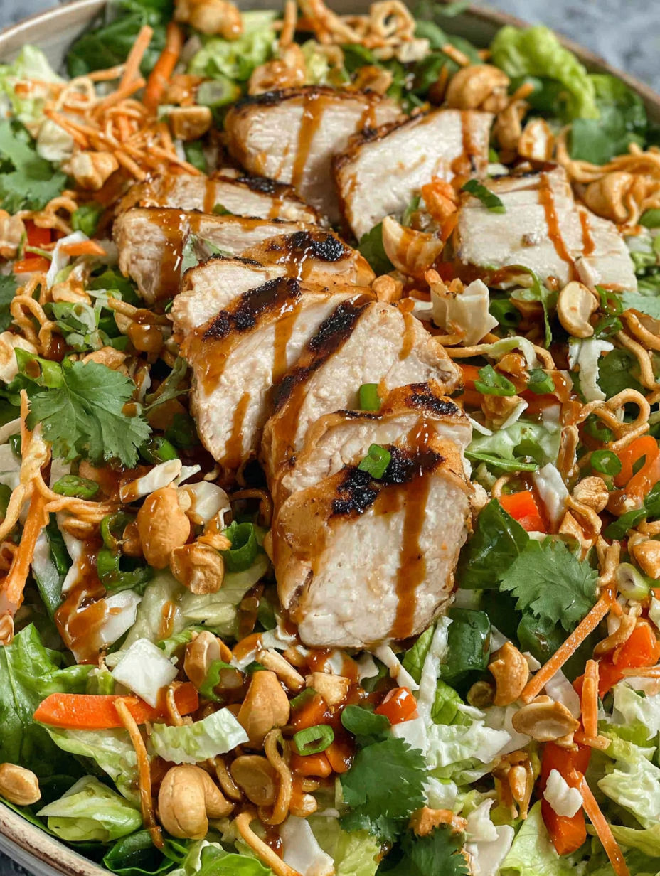 A chicken cashew crunch salad with a drizzle of sauce.