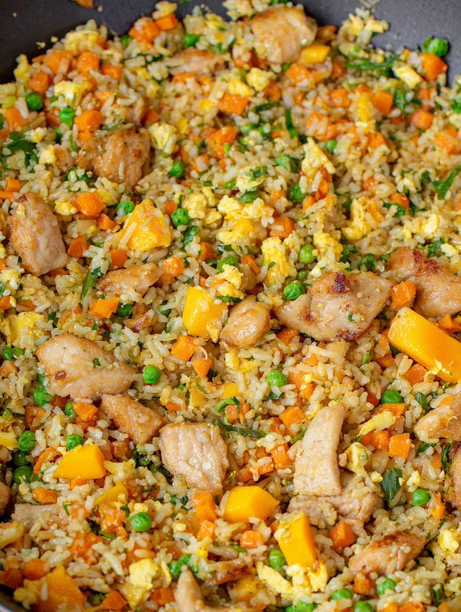 Mango chicken fried rice with peas and carrots.