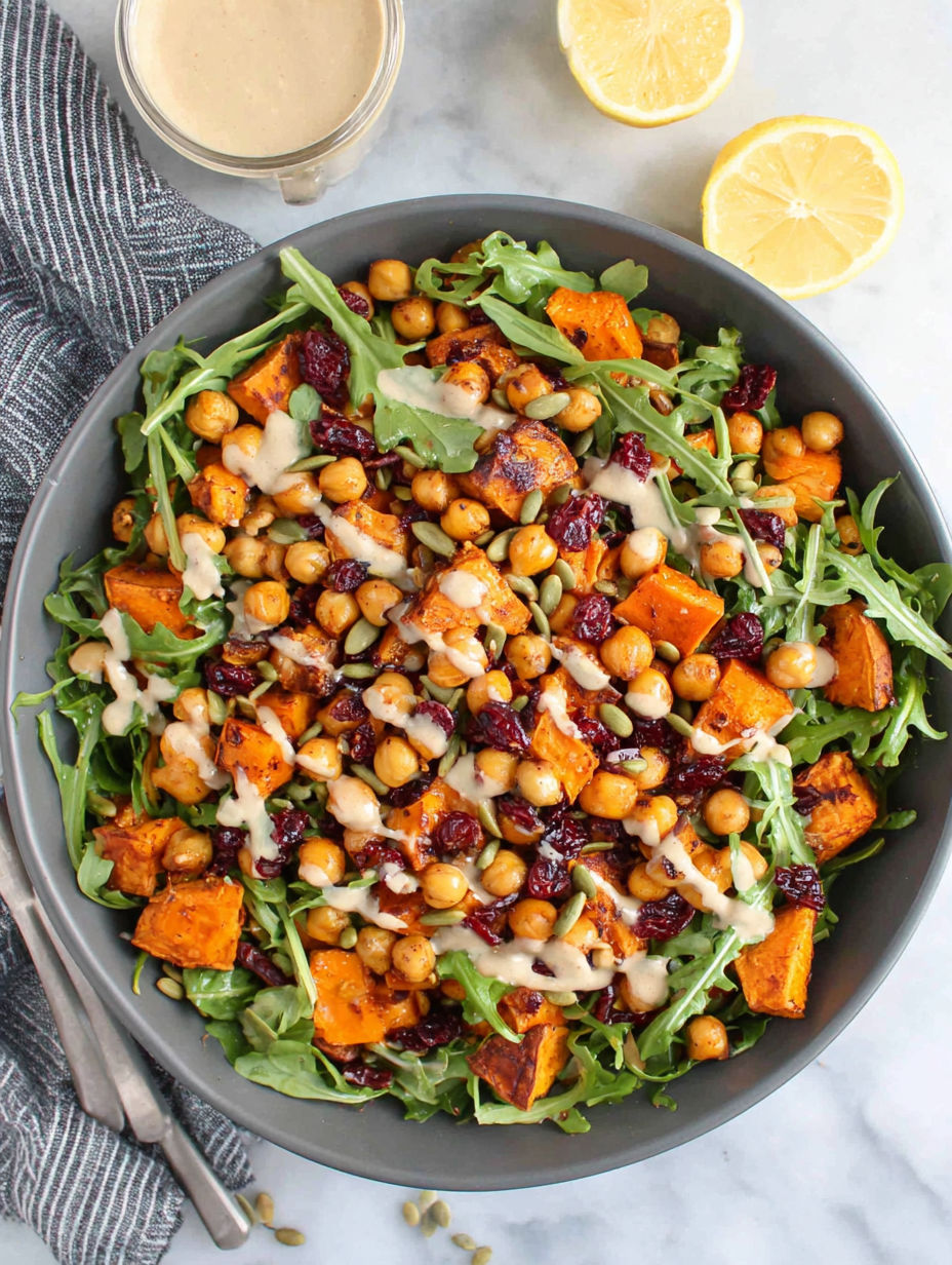 A bowl of roasted chickpea and sweet potato salad with a sweet tahini dressing.