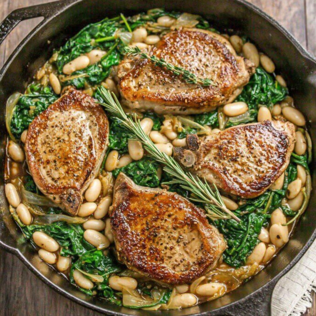A skillet dinner with pork chops, white beans, and spinach.