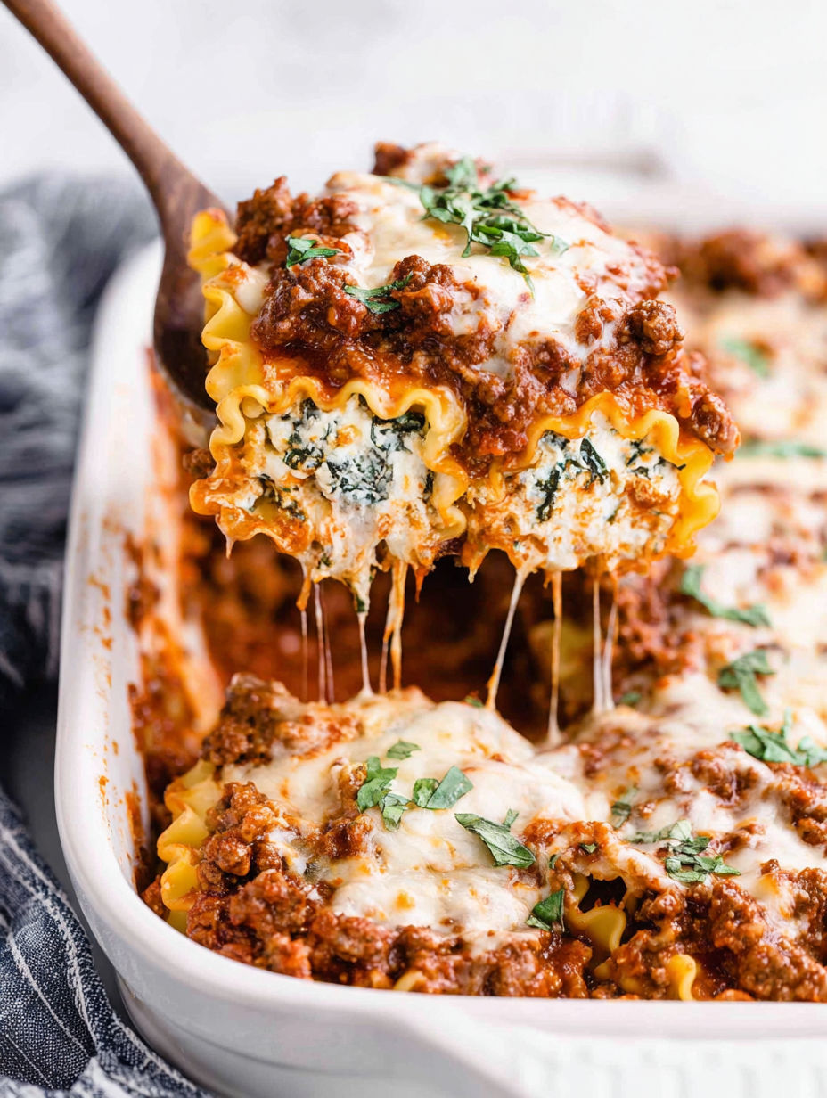 A dish of lasagna roll-ups with sauce.