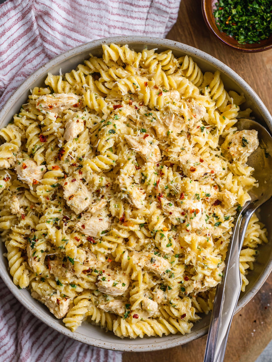 A bowl of pasta with chicken and garlic.