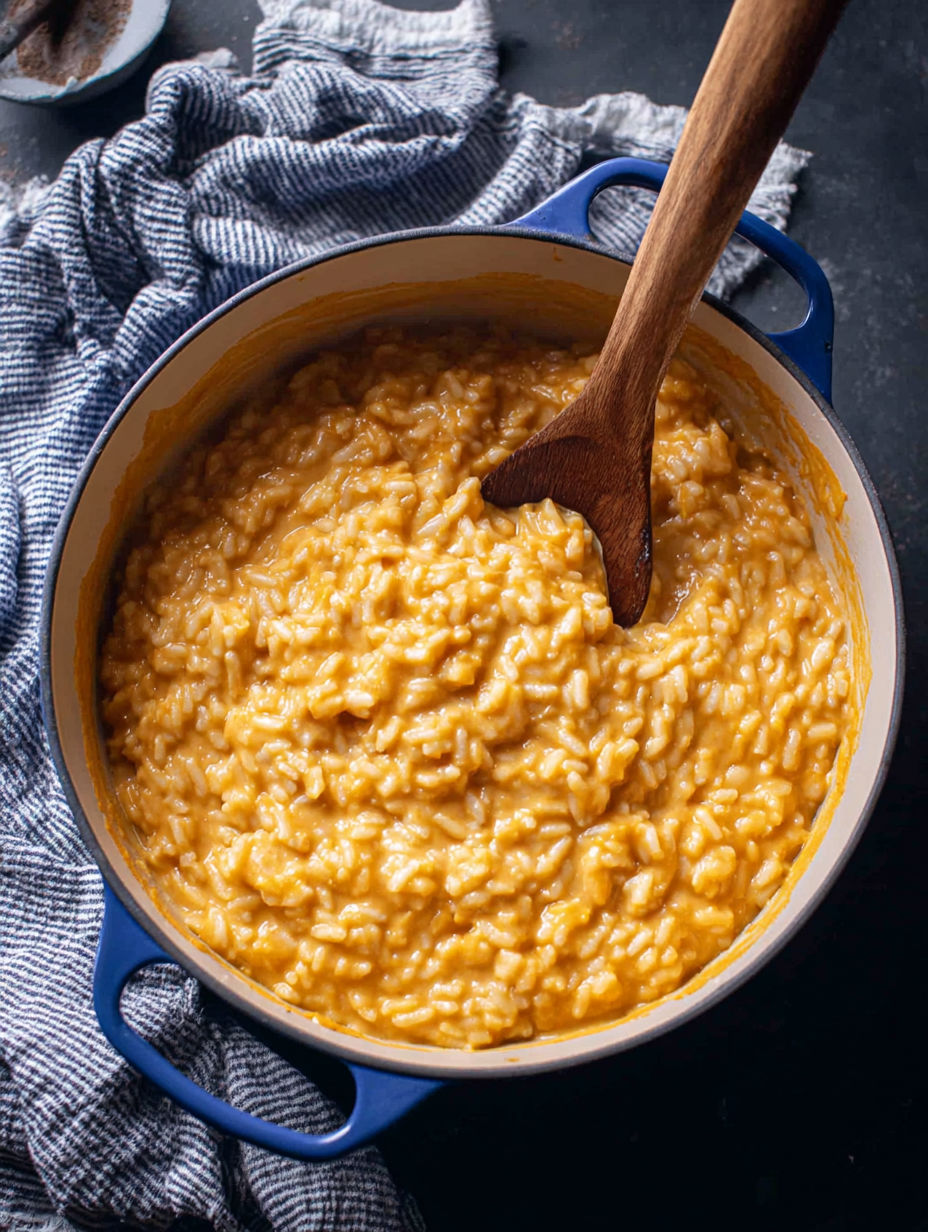 A wooden spoon in a bowl of rice.