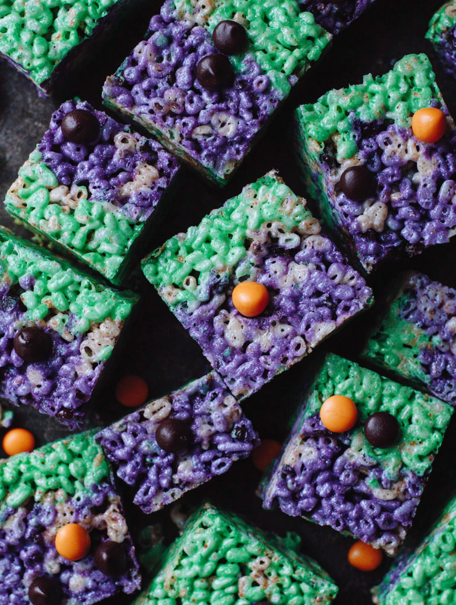 A close up of a green and purple cake with orange and chocolate toppings.