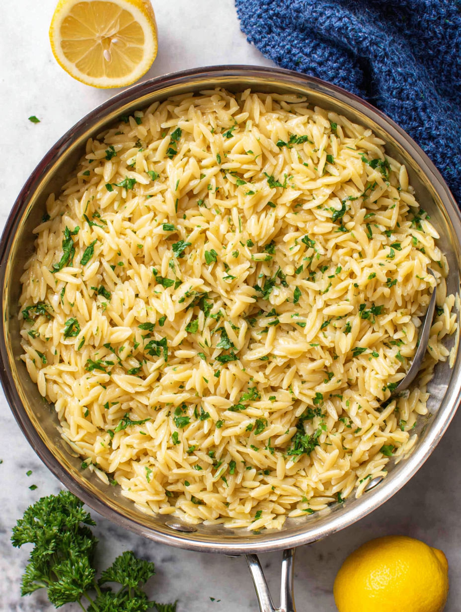 A bowl of rice with green herbs on top.