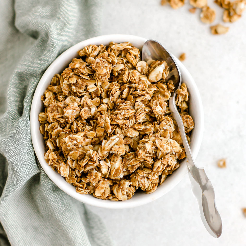 A bowl of granola with a spoon in it.