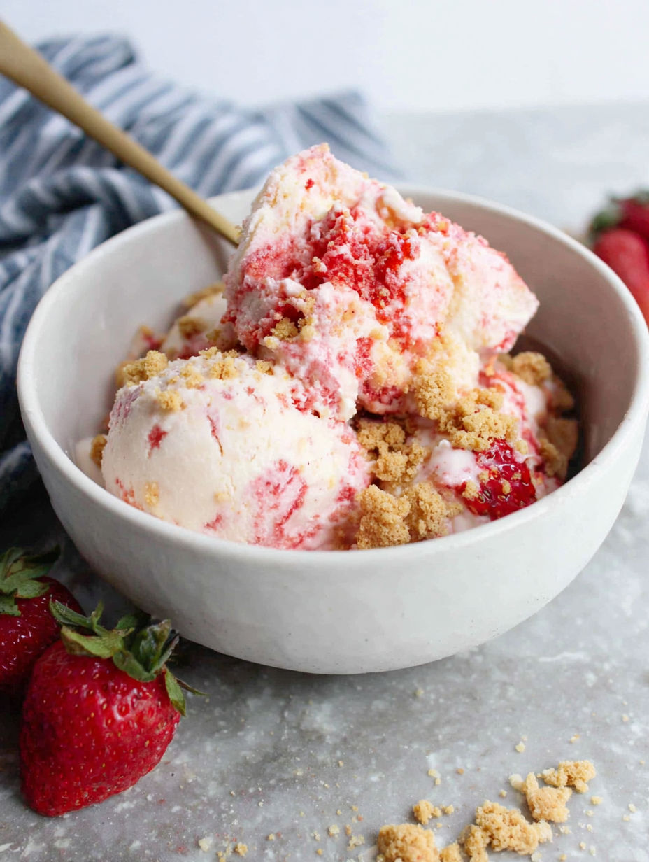 A bowl of ice cream with strawberries on top.