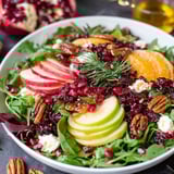 A bowl of salad with various fruits and vegetables.