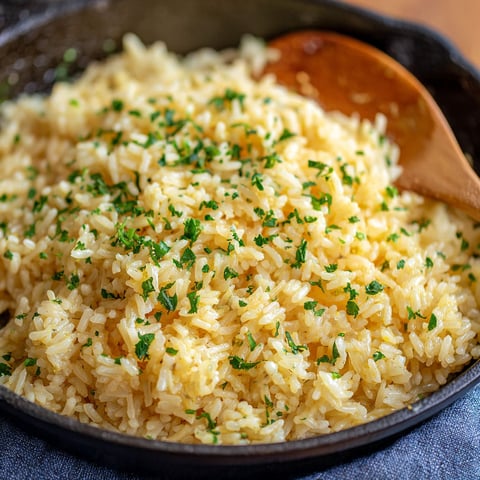 A close up of a dish with rice and green herbs.