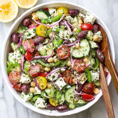 A white bowl filled with a Greek salad.