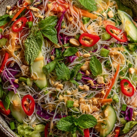 A bowl of spring roll salad with peanut dressing.
