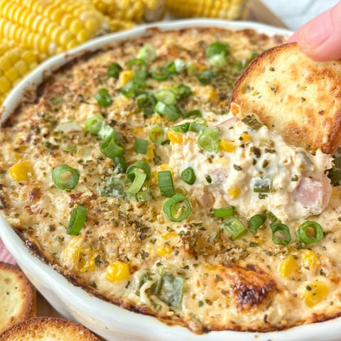A hand is grabbing a piece of corn bread.