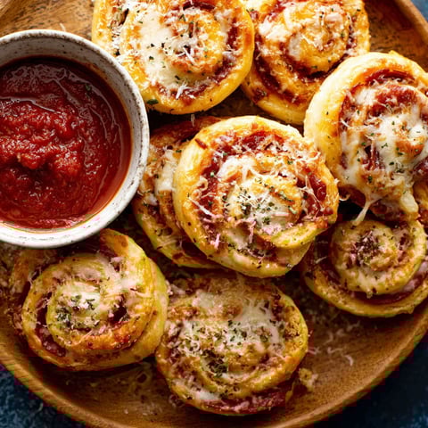A plate of pizza wheels with sauce.