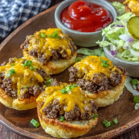 A plate of cheeseburger cups with ketchup and lettuce.