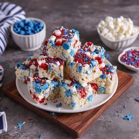 A plate of Rice Krispie treats with red, white and blue colors.
