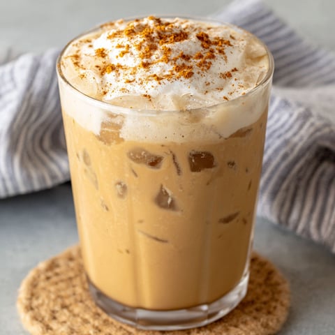 A glass of iced chai tea latte with pumpkin cold foam.