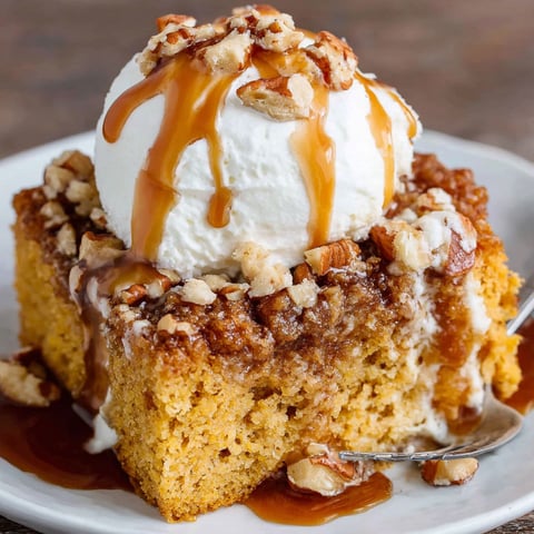 A slice of pumpkin spice cake with a scoop of ice cream on top.