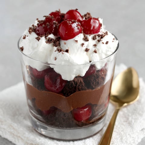A glass bowl filled with a chocolate dessert.