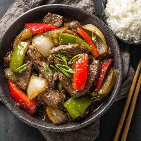 A bowl of beef and peppers in a slow cooker.