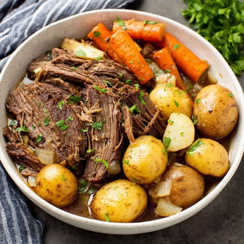 A bowl of beef and potatoes.