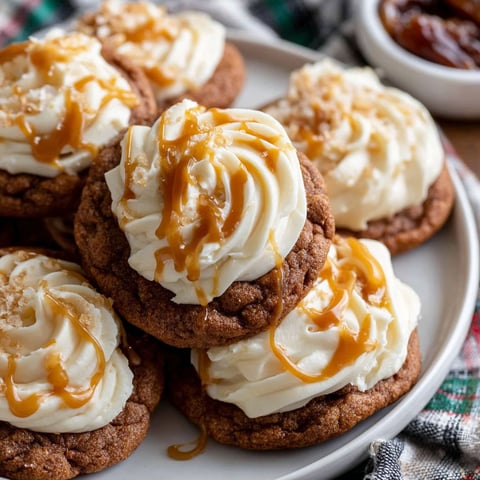 A plate of cookies with white icing and caramel drizzle.
