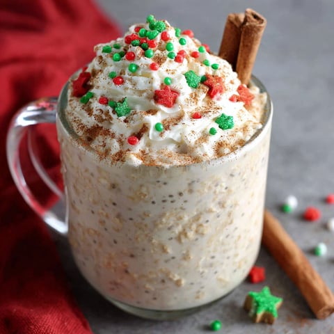 A glass of eggnog oatmeal with cinnamon sticks.